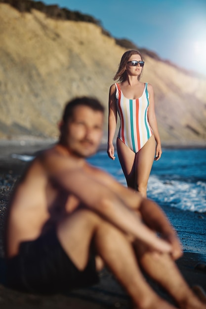 Jeune couple sur la plage. Concentrez-vous sur la femme qui regarde la mer en arrière-plan.