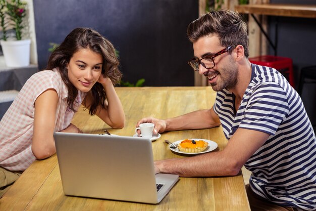 Jeune couple, portable utilisation, dans, cafétéria