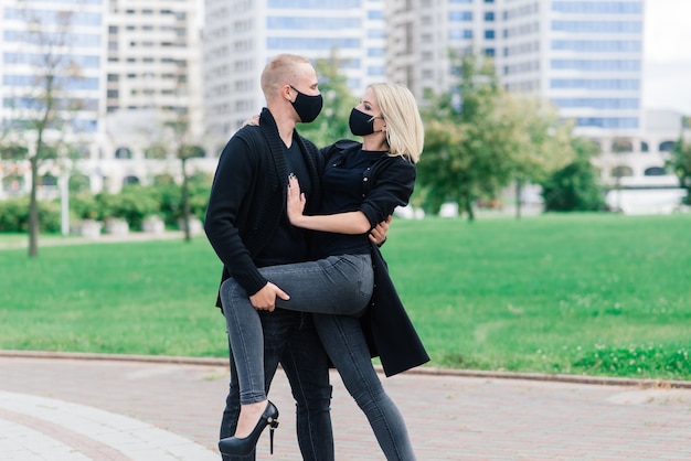 Jeune couple portant des masques de protection dans la ville