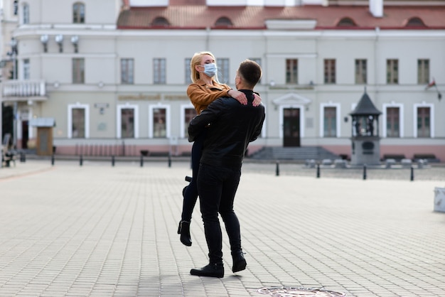 Jeune couple portant des masques de protection dans la ville