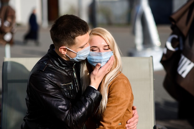 Jeune couple portant des masques de protection dans la ville