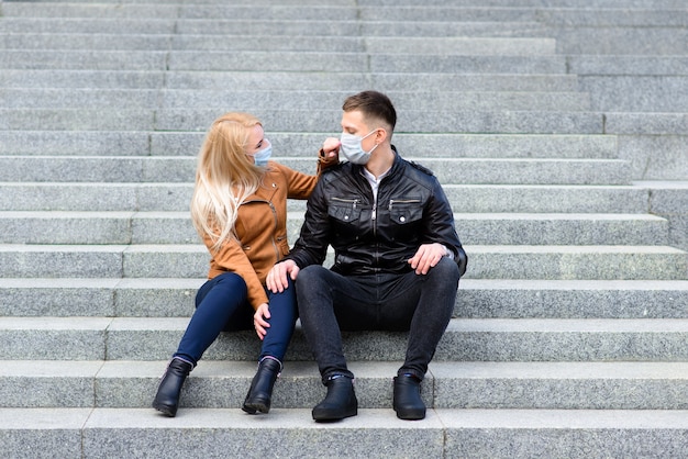 Jeune couple portant des masques de protection à l'extérieur