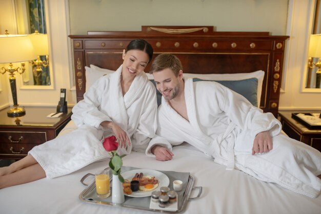 Un jeune couple prenant un petit-déjeuner romantique à l'hôtel.