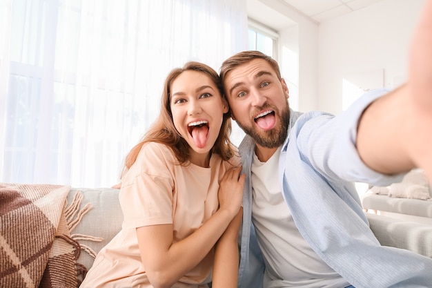 Jeune couple prenant selfie à la maison