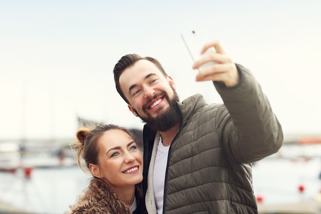 Photo jeune couple prenant selfie