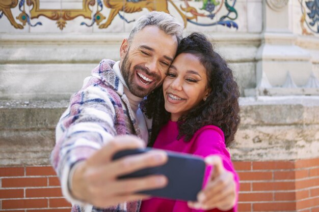 Jeune couple prenant des selfies faisant des grimaces