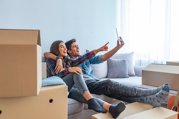 Jeune couple prenant des selfies avec sa tablette dans leur nouvelle maison