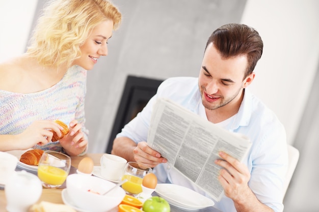 jeune couple prenant son petit déjeuner dans la cuisine