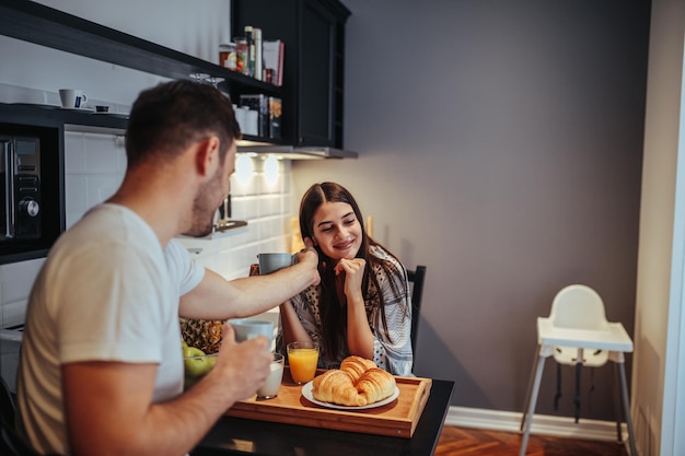 Jeune couple prenant son petit déjeuner dans la cuisine