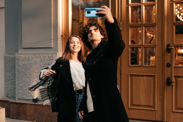 jeune couple prend un selfie à l'extérieur en automne