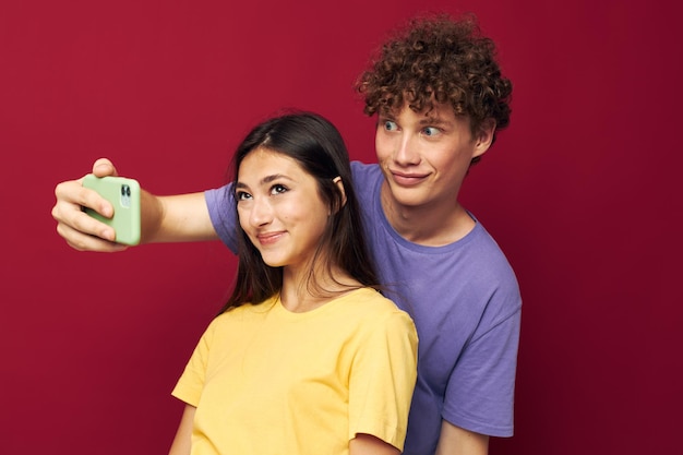 Un jeune couple prend un selfie posant câlin fond isolé