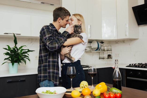 Un jeune couple prépare un dîner sain dans une cuisine moderne.