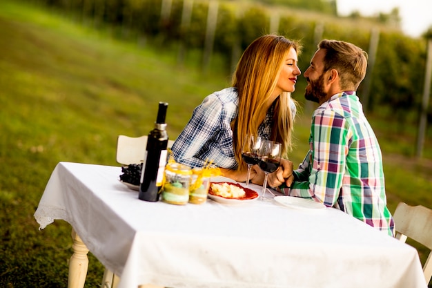 Jeune couple près de la table dans le vignoble