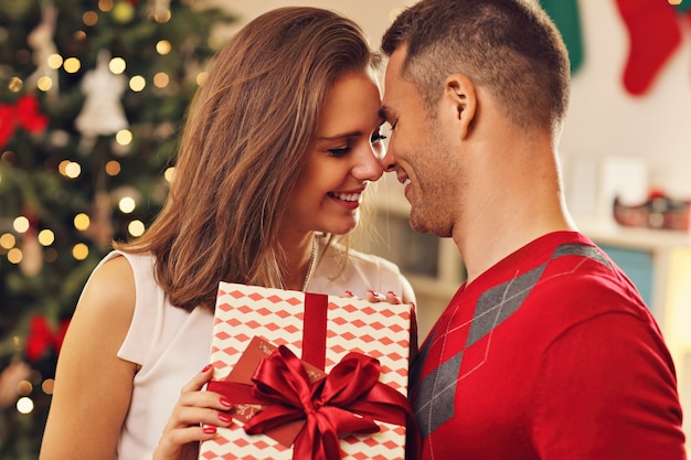 jeune couple, à, présent, sur, arbre noël