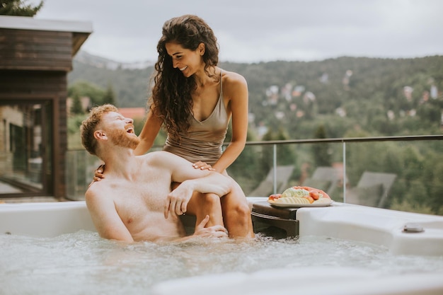 Jeune couple profitant d'un bain à remous extérieur en vacances