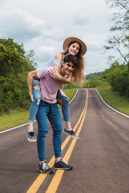 Jeune couple profiter d'une promenade sur la route.