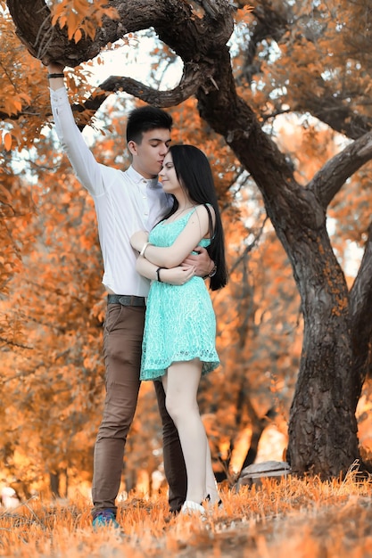 Jeune couple en promenade en automne beau parc au coucher du soleil