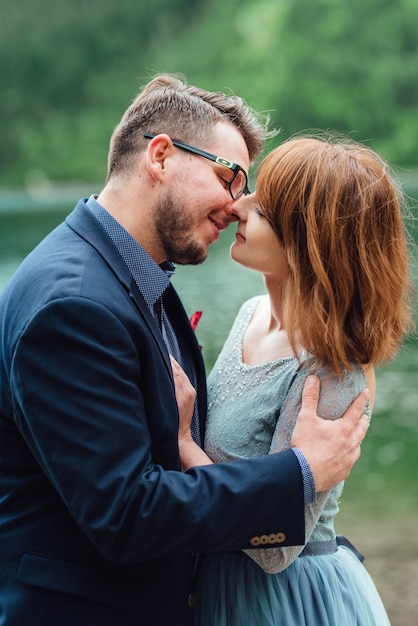 Jeune couple en promenade près du lac entouré par les montagnes des Carpates