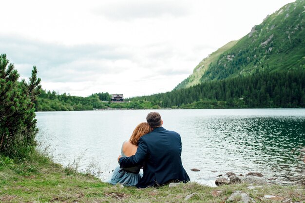 Jeune couple en promenade près du lac entouré par les montagnes des Carpates