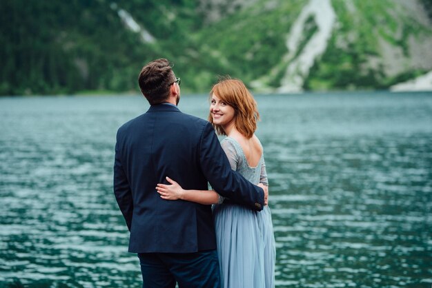 Jeune couple en promenade près du lac entouré par les montagnes des Carpates