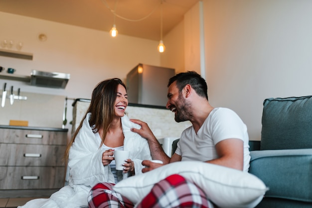 Jeune couple en pyjama à la maison.