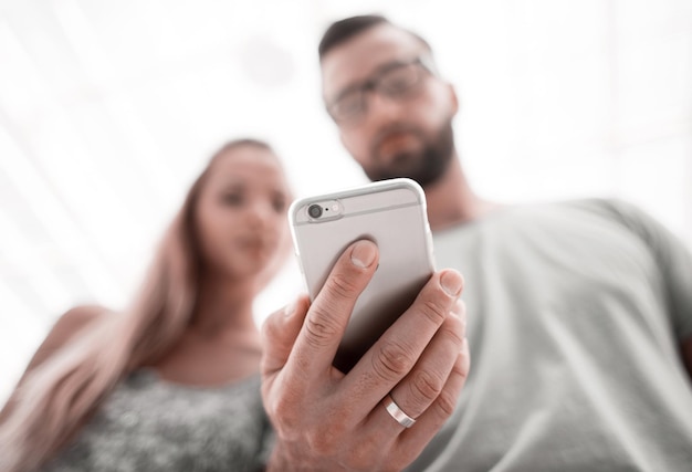 Jeune couple à la recherche de photos sur smartphone