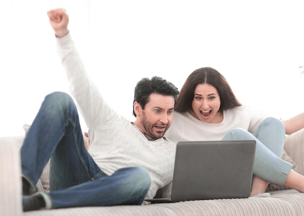 Jeune couple regardant une émission de télévision sur son ordinateur portable