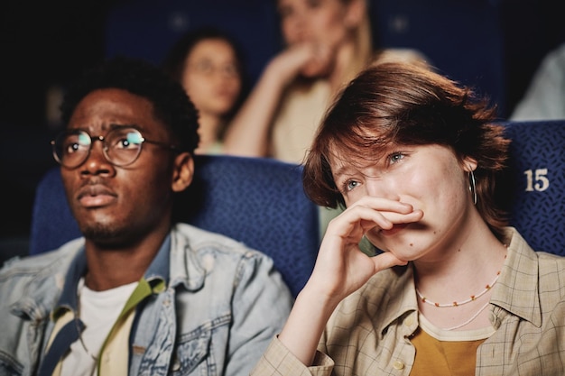 Jeune couple regardant un film triste