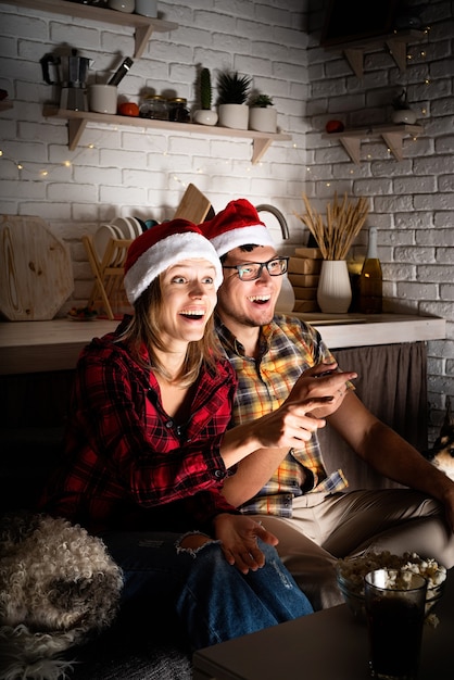 Jeune couple regardant des films à la maison