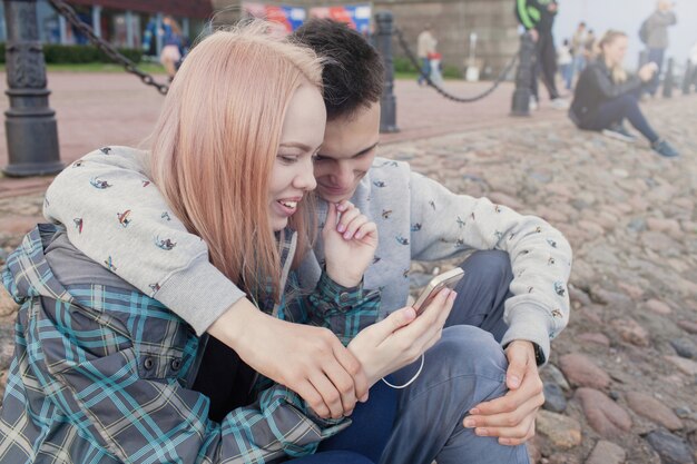 Jeune couple en regardant une vidéo sur un smartphone.