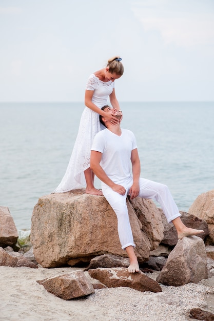 Jeune couple sur les rochers dans la mer