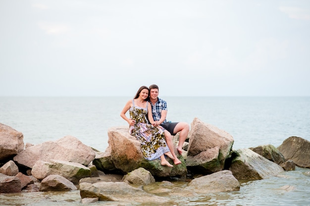 Jeune couple sur les rochers de la mer