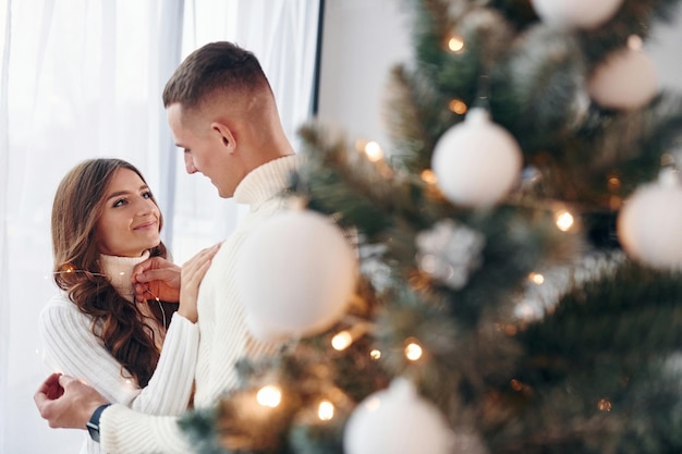 Jeune couple romantique célèbre le nouvel an ensemble à l'intérieur