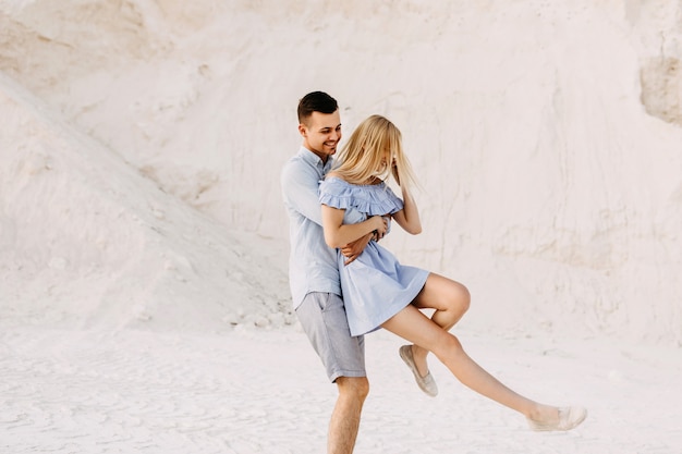 Jeune couple romantique à l'extérieur s'amuser. Homme filature femme, souriant.