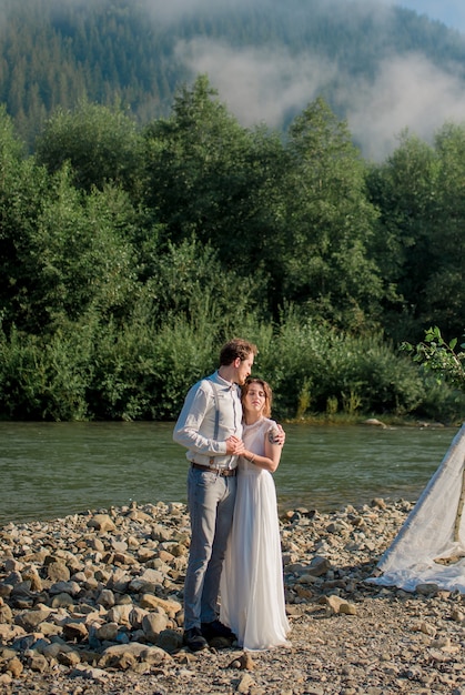 Jeune couple romantique de mariage de la mariée en robe blanche