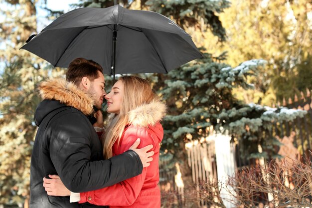 Jeune couple romantique avec parapluie dans le parc