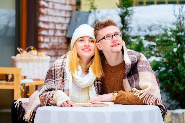 Jeune couple romantique partageant un biscuit au café de la rue en plein air.