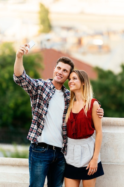 Jeune couple romantique prenant une photo avec un téléphone portable. Notion de relation.
