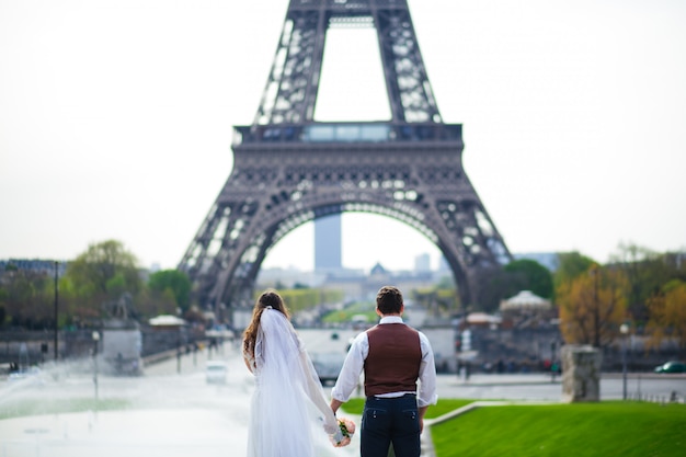 Jeune couple romantique près de la tour Eiffel au petit matin à Paris, France