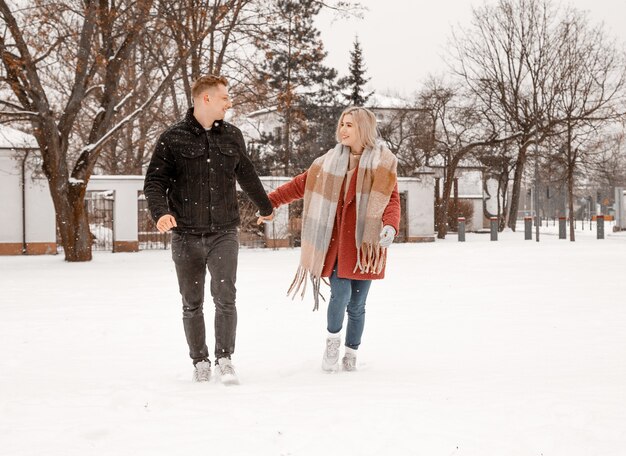 Jeune couple romantique s'amuse à l'extérieur en hiver. Deux amoureux s'embrassent et s'embrassent à la Saint-Valentin.