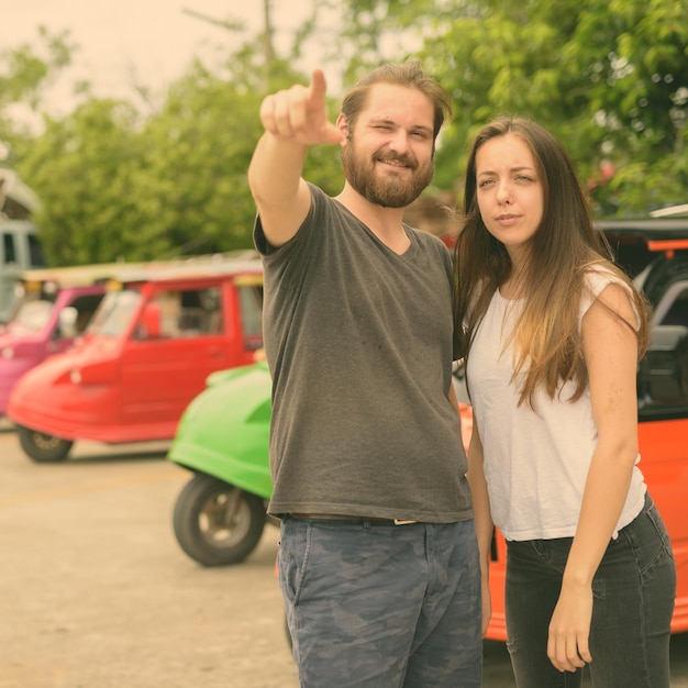 Photo un jeune couple sur la route en ville.