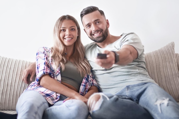 Jeune couple s'amusant sur le canapé du salon