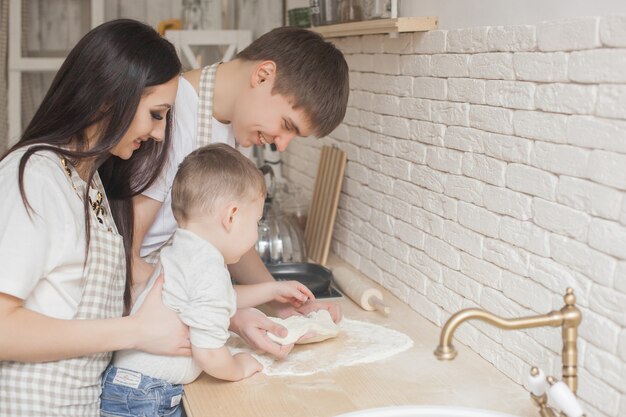 Jeune couple s'amusant à la cuisine. Cuisine familiale ensemble. Homme séduisant et belle femme sur fond de cuisine.