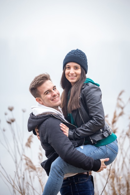 Photo jeune couple s'amusant dans la nature un jour d'hiver brumeux