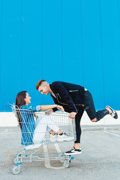 Photo jeune et couple s'amusant dans un panier en fond bleu.