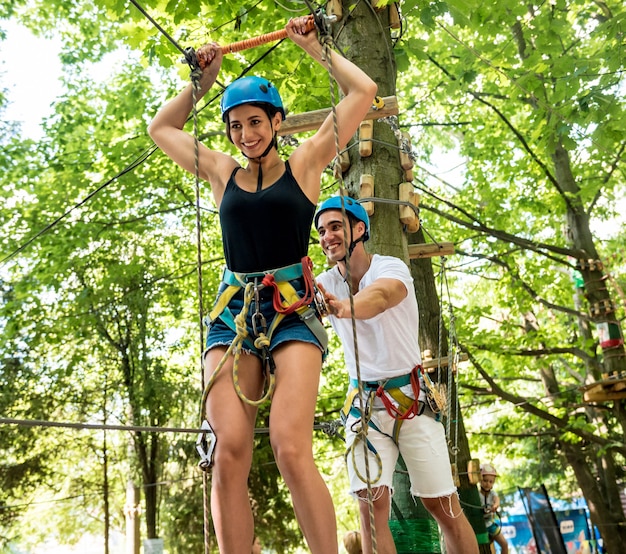 Jeune couple s'amusant dans le parc de corde d'aventure