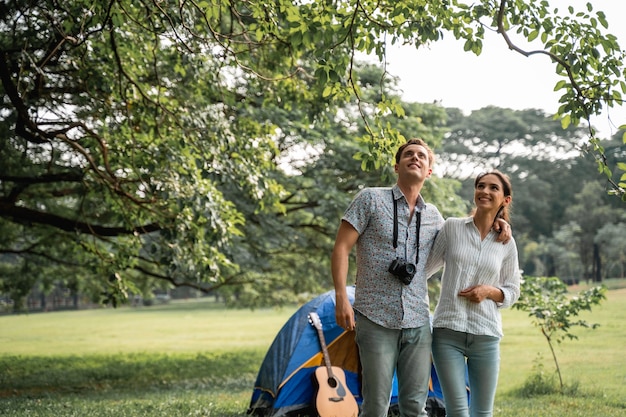 Jeune couple s'amusant avec guitare sur pique-nique et camping dans le parc