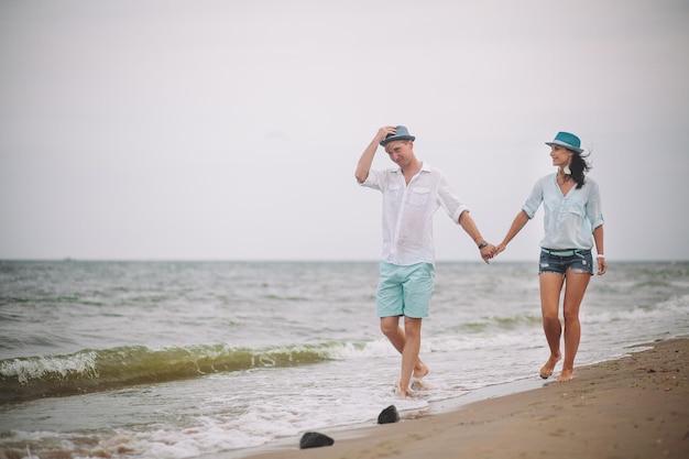 Jeune couple s'amuse le jour d'été à la plage