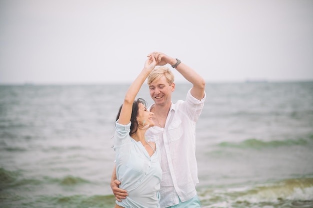 Jeune couple s'amuse le jour d'été à la plage