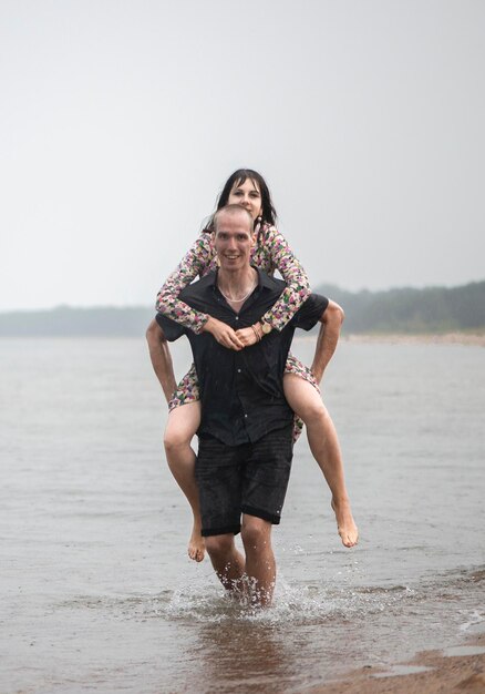 Un jeune couple s'amuse sur la plage un jour d'été humide.